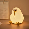 Cute kiwi bird silicone night lamp glowing warmly on a bedside table