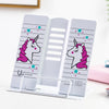 Cute unicorn-themed adjustable metal book stand with pink and teal star design on a white background.