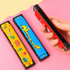 A collection of assorted metal mouth organs with bright blue, red  and yellow cartoon designs showcasing the black plastic mouthpiece holes.
