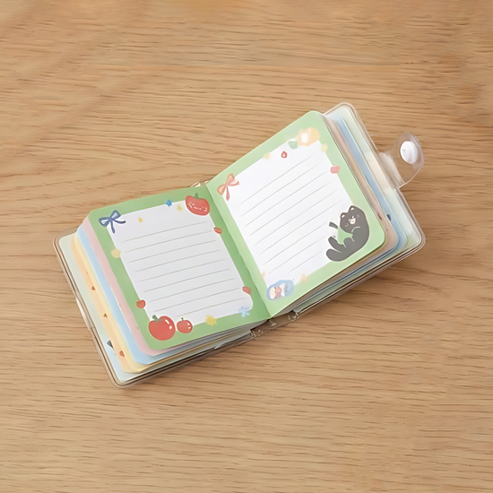 Close up of "Apple Cat" red mini notebook with snap button and keychain attachment.