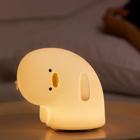 Why Duck silicone night lamp glowing warmly on bedside table