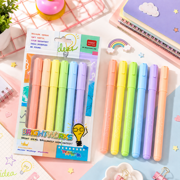 Six colorful pastel highlighters spread out on a desk next to an open economics textbook and a ring-bound summary notebook.