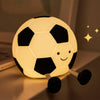 Football silicone night lamp glowing warmly on a bedside table