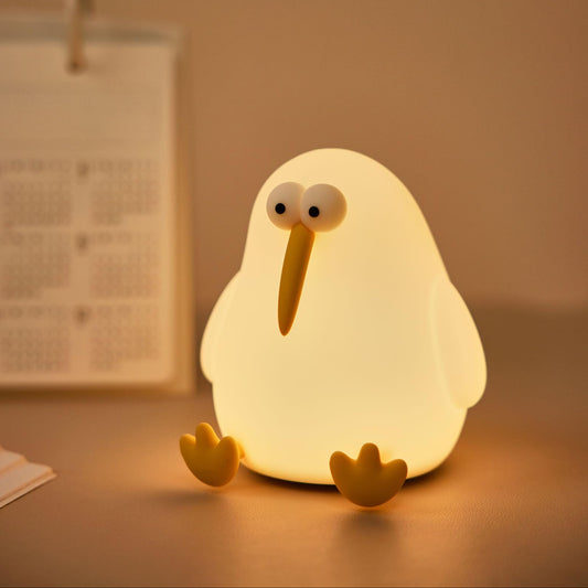 Cute kiwi bird silicone night lamp glowing warmly on a bedside table