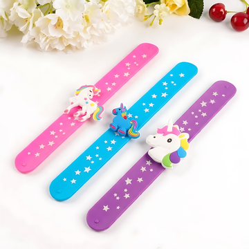 Three colorful silicone slap bands in purple, pink, and blue featuring 3D unicorn characters and star patterns.