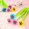 A collection of colorful capybara flower shake gel pens displayed on a pastel background next to an open notebook.