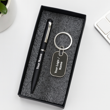 Black pen and keychain set with customizable text in a box on a white surface.