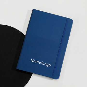 Navy blue A5 hardbound notebook with elastic closure strap on a white background.
