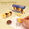 Close-up of detached cookie eraser pieces showing the assembly pegs alongside a completed yellow swirl cookie erasing pencil marks on paper.