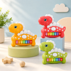 Group of colorful red, green, and orange dinosaur-shaped musical piano toys for kids.