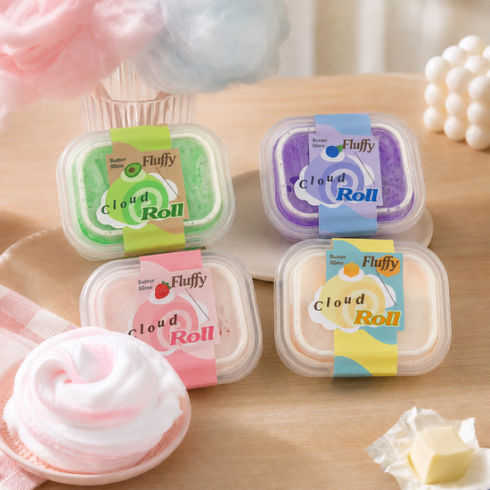 Four Fluffy Cloud Roll dessert containers arranged on a wooden table with whipped cream and cotton candy props. The containers are green, purple, pink, and yellow, with colorful labels reading 'Fluffy Cloud Roll' and 'Butter Cream'.