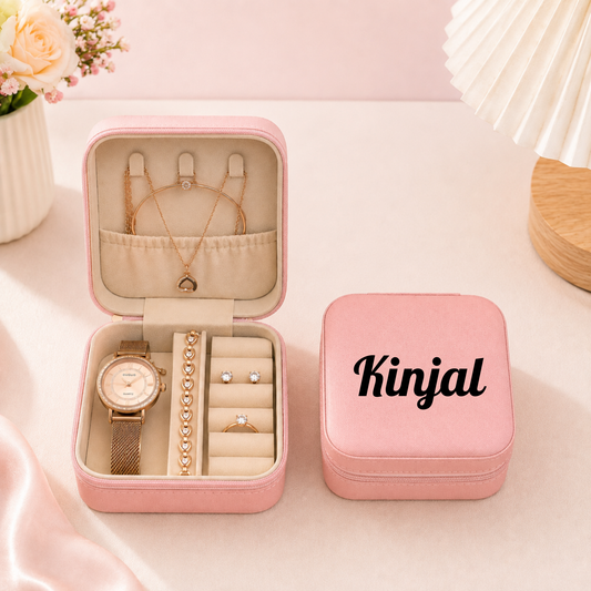 Open pink leather travel jewelry box displaying watch necklace ring and earrings with closed box beside it