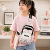 A young girl wearing a pastel unicorn and rainbow print custom name sling bag featuring the name "Helly" on the front pocket while holding a book.