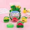 Cute watermelon shaped dual hole pencil sharpeners with transparent shavings collectors on a reflective desk.