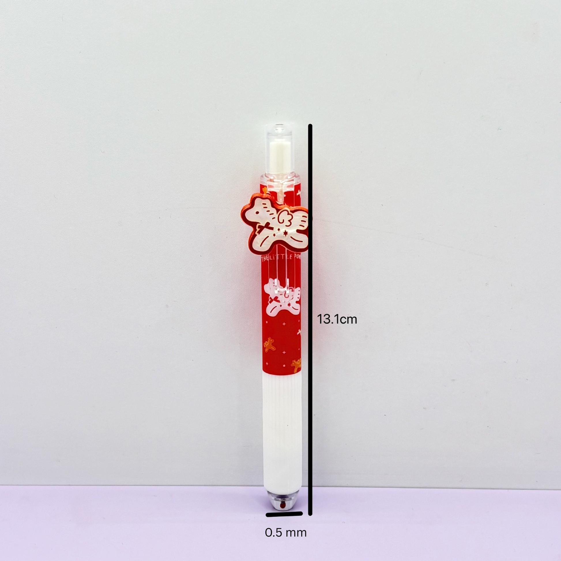 A detailed side view of a single red and white clicker pen indicating dimensions of thirteen point one centimeters long and zero point seven centimeters wide