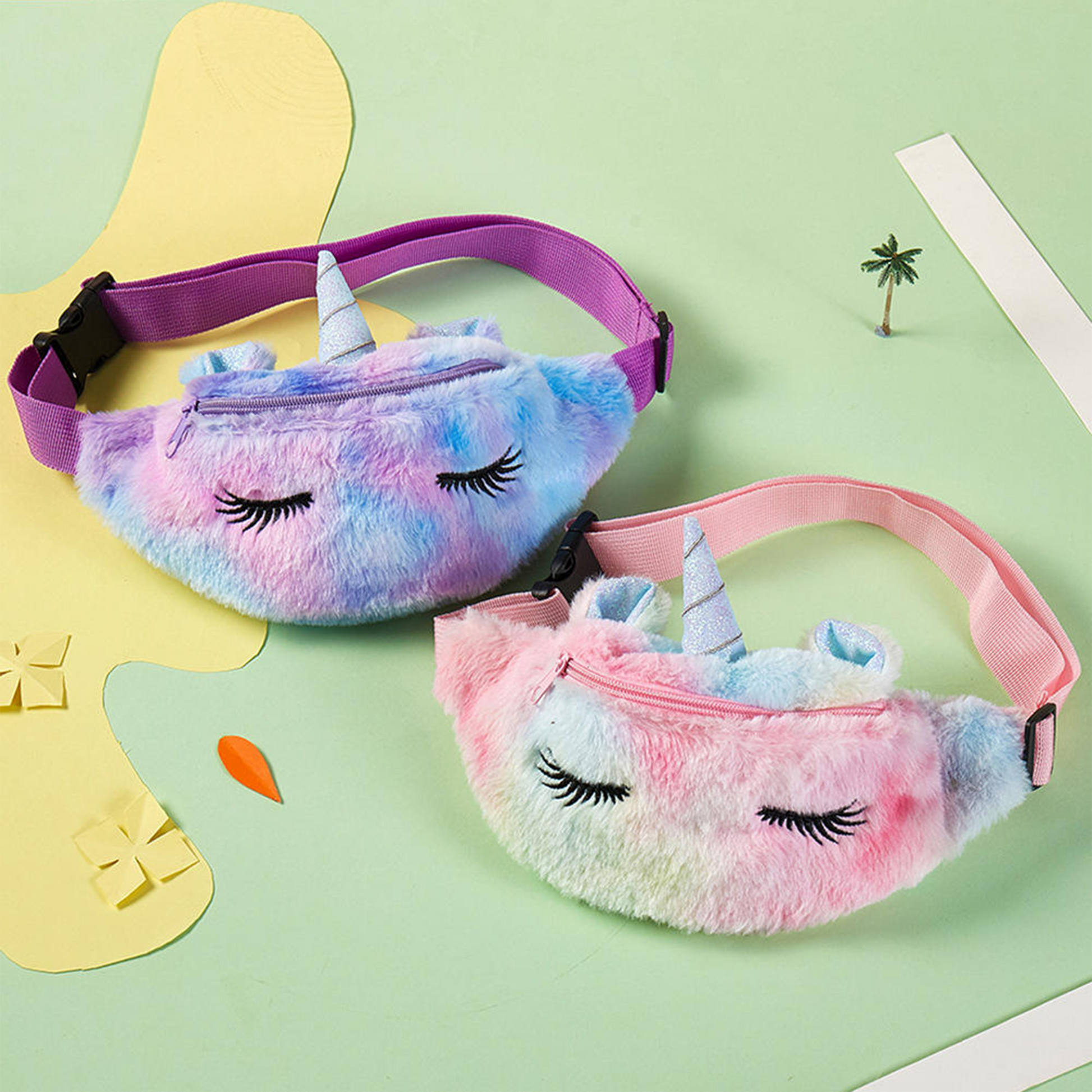 Close up of fluffy unicorn waist bags in gradient purple and pink colors with adjustable straps.