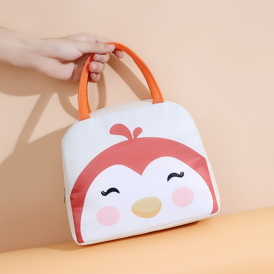 Close-up of a white and pink penguin-themed insulated lunch box bag with orange handles on a solid background.