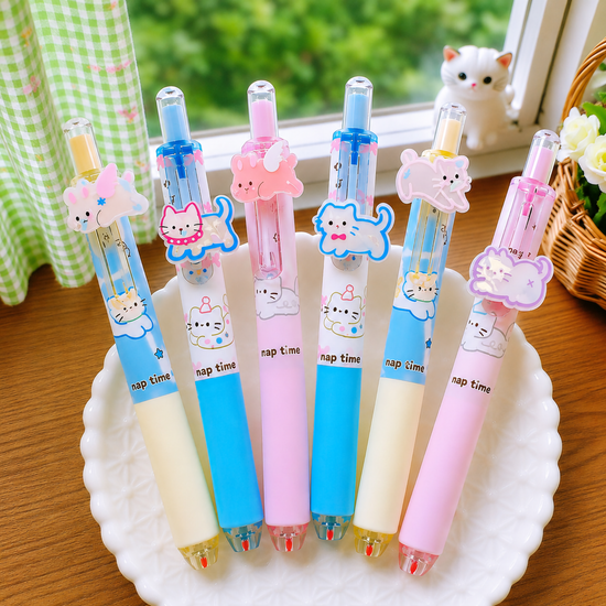 Six adorable cat-themed school stationery click pens neatly arranged side-by-side in a wavy white ceramic dish near a window setup.
