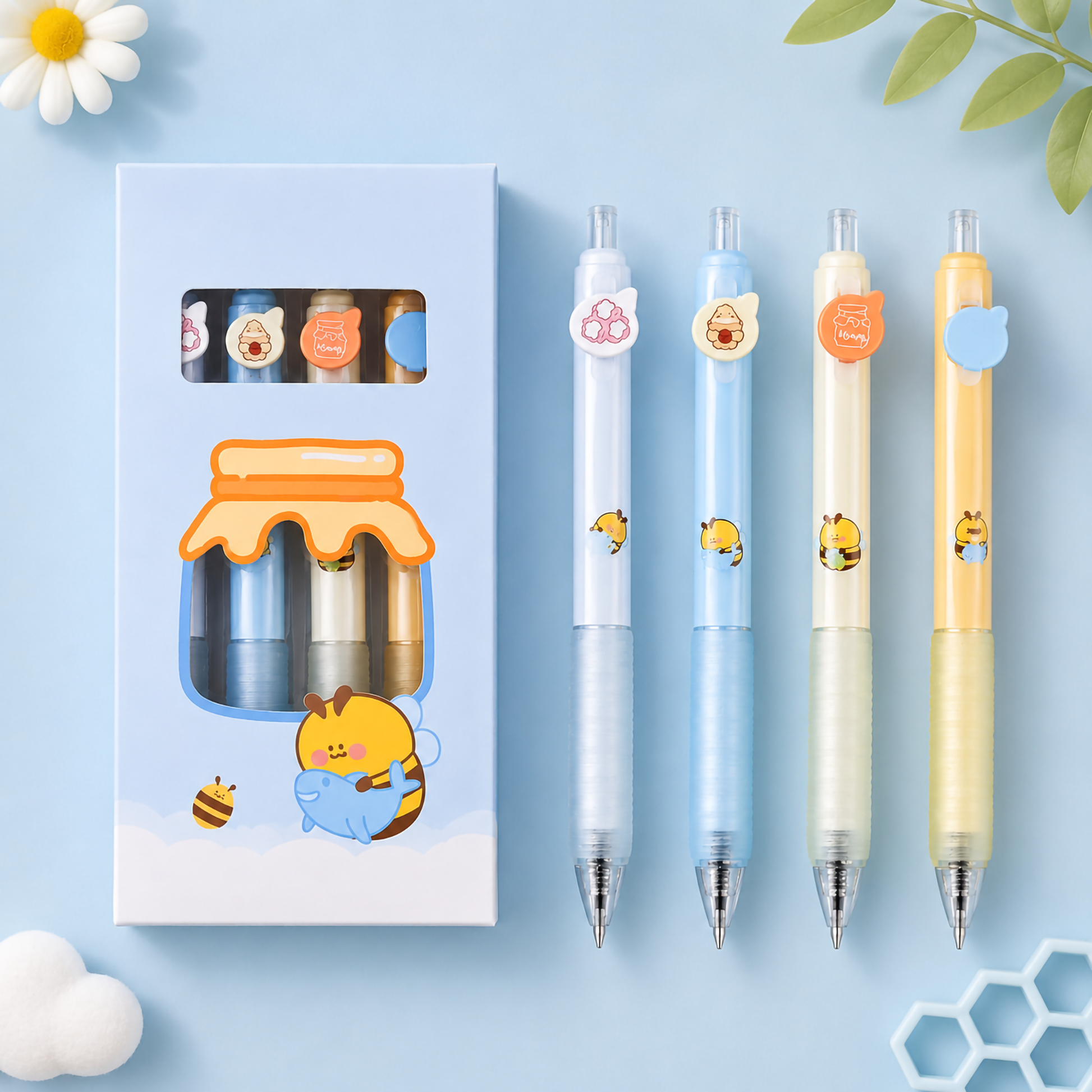 Two sky-blue retail window boxes displaying the four-piece "Bee" retractable gel pen sets, placed over a soft blue background