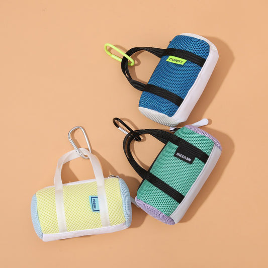 A colorful collection of mini mesh duffle bag coin pouches with carabiner clips laid out flat.