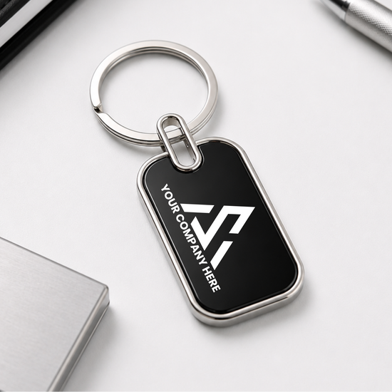 Black keychain with a silver ring on a white surface with office supplies.