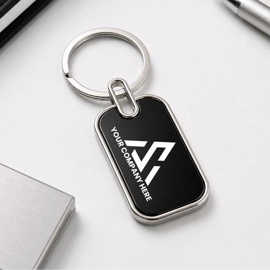 Black keychain with a silver ring on a white surface with office supplies.