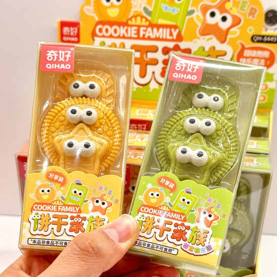 Cookie Family eraser set featuring colorful biscuit and star-shaped erasers with cute cartoon eyes in brown, yellow, and green.