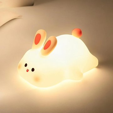 Soft silicone big face rabbit night light glowing on bedside table