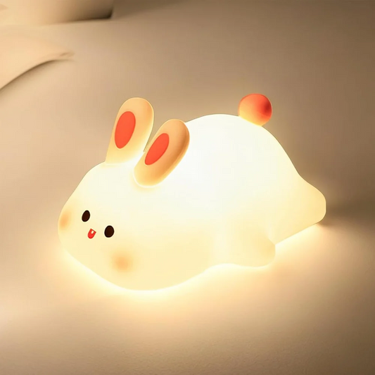 Soft silicone big face rabbit night light glowing on bedside table