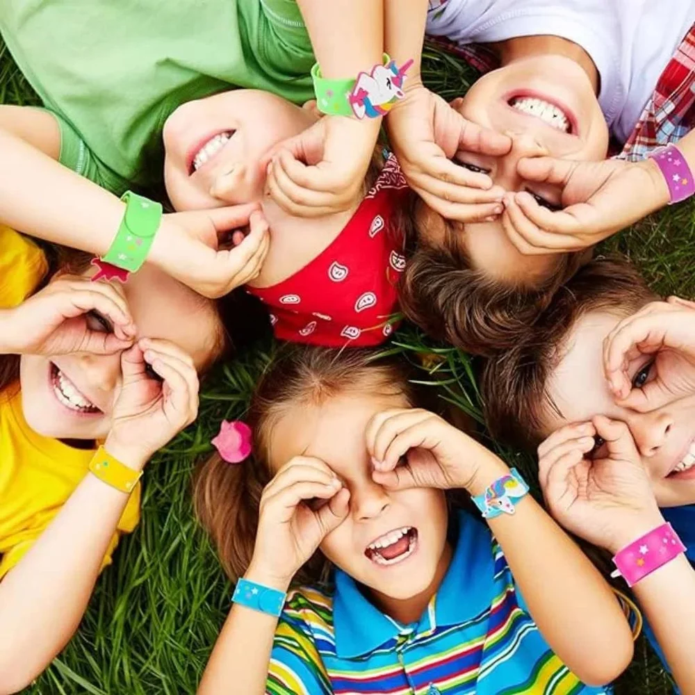 Pink slap bracelet curled into a ring showing a white unicorn charm with a rainbow mane.